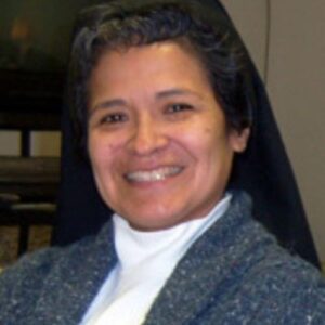 A woman wearing a nun 's outfit smiling for the camera.