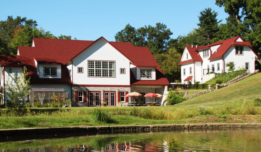 A group of houses with red roofs near water.