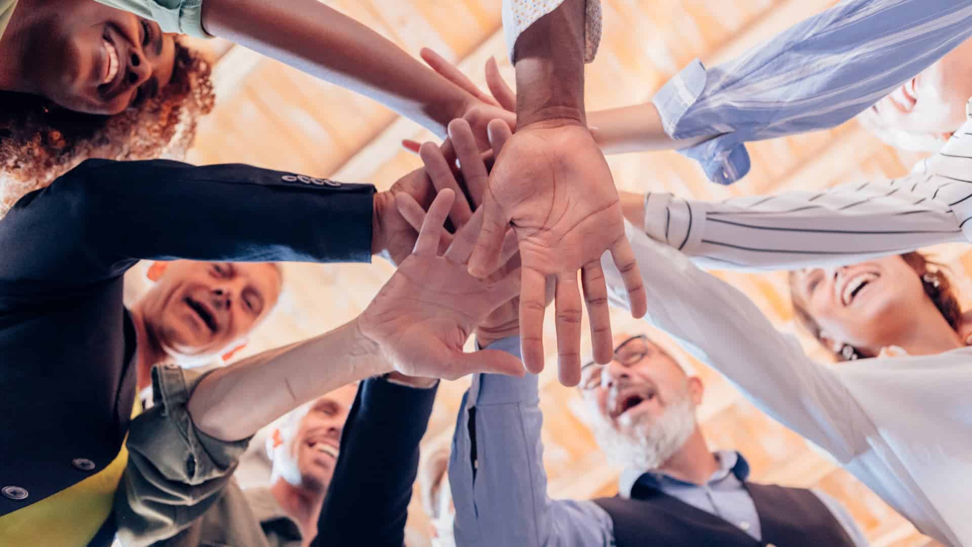 A staff huddling with their hands on top of each other.