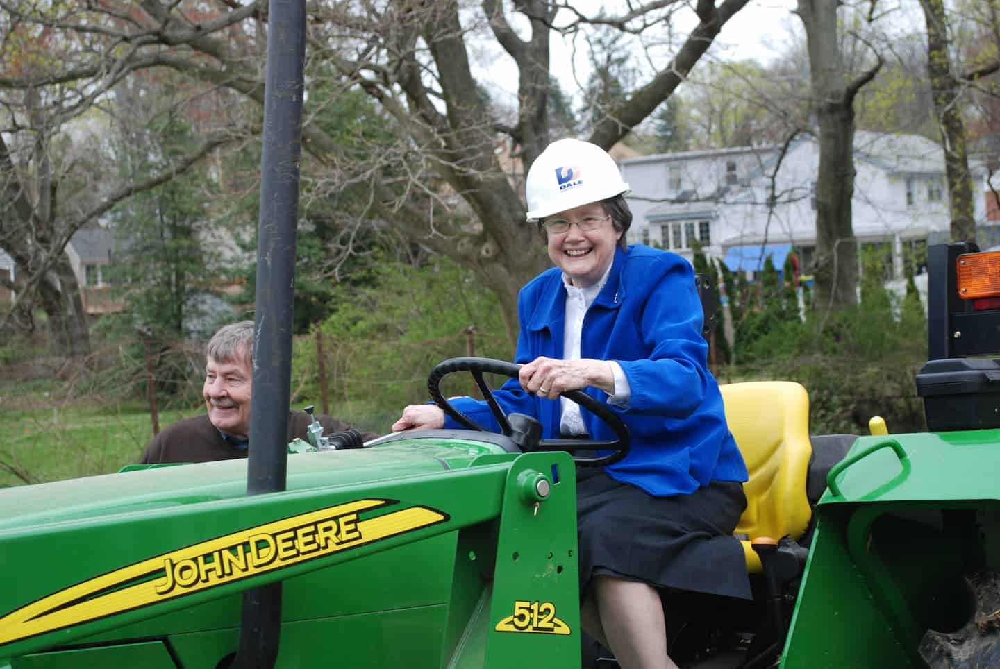 Mary Trainer and Ski on a John Deere truck with a hard hat on.