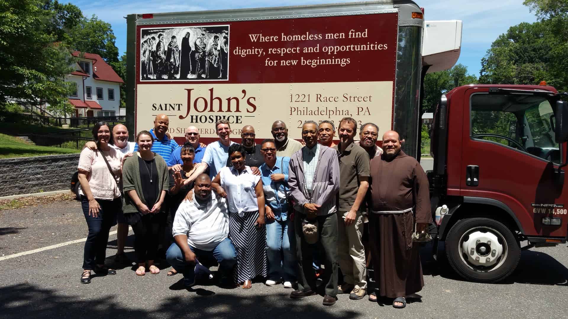 St. John's Hospice visiting Cranaleith for a large group retreat with their truck and Cranaleith's grounds behind them.